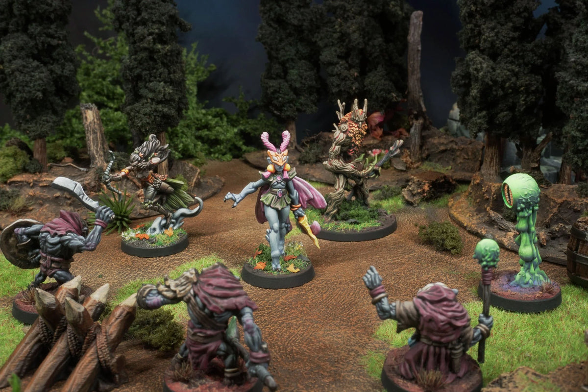 Miniature figurines on a forest-themed gaming mat